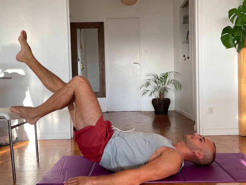 Man performing a plank exercise in a well-lit room.