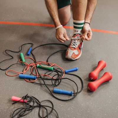Person tying shoelaces on running shoes before a workout.