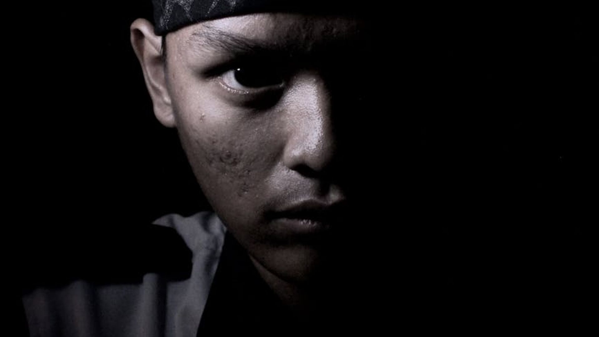 Silhouette of a man in a powerful stance against a dark background.